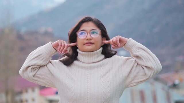 Angry, cunning teenager girl covers her ears with her fingers. She refuses to listen to the information. Displeased irritated sad angry distempered young girl teen student do not want to listen. 