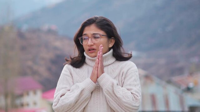 Portrait of Indian woman feel extremely cold  during winter in Lahaul, India. Unhealthy female feeling discomfort try to warming up outdoors. Girl  warming palms. Concept of cold temperature.