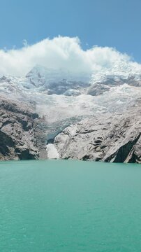 Aerial of Turquoise Lagoon 513 with Snow-Capped Mountains, Vertical Tilt