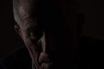 Dark close-up of an old man