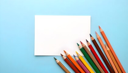 Blank greeting card mockup on pastel blue background with coloring pencils. Flat lay design