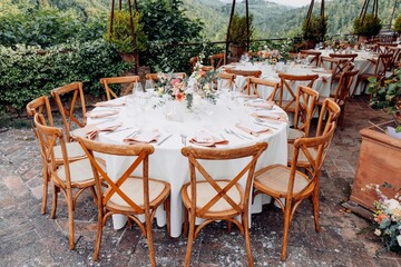 Elegant outdoor dining setup with floral centerpieces.