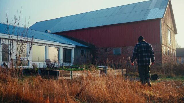 Caucasian Man At The Backyard With Garden Raised Bed During Sunrise. Wide Shot
