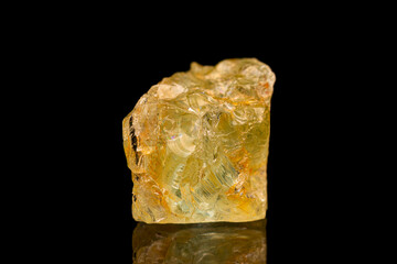 Natural rough golden beryl (beryl group) gemstone on dark background (selective focus)