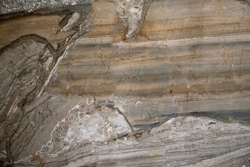 Close-up of a textured stone with beige and orange hues and crack details