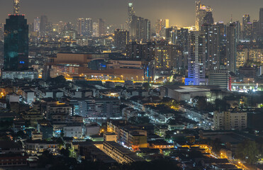 Fototapeta premium Nightscape view after sunset of Skyscrapers in the business district of downtown in the Bangkok city. City night view of Modern buildings after sunset with bright glowing lights, use as your Wallpaper