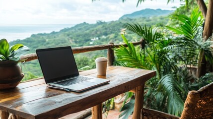 Fototapeta premium Laptop on a wooden table with a tropical mountain view