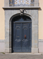 Baroque portal with wooden door at the royal cloth manufacture building in the old town of Carcassonne, France