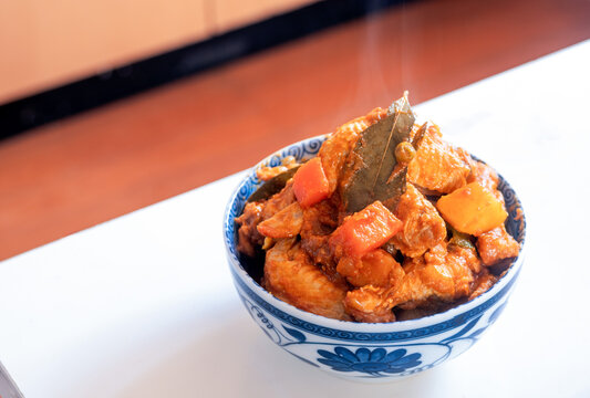 Newly cooked chicken afritada in a bowl on the table - a Filipino dish