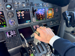 Pilot setting or adjusting engine thrust levers in jet airplane