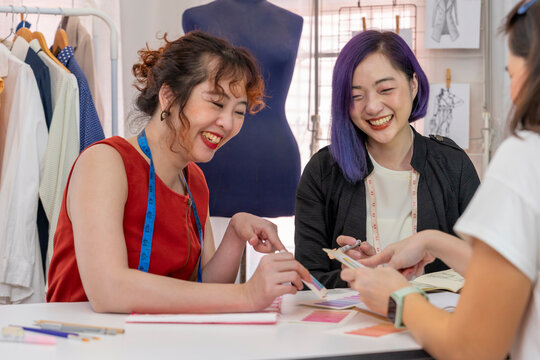 dressmaker and fashion designer business partnership explaining clothes design with color swatches and sketches to a client,females fashion stylist at work in workshop - Powered by Adobe