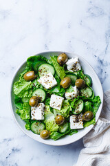 Green Greek salad with olives, feta cheese and cucumber.