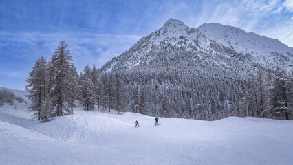 Naklejka premium This picturesque winter landscape features snowy mountains and enthusiastic skiers, making it an ideal destination for outdoor adventures, Montgenevre ski village, Alps, France