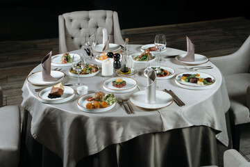 Beautifully organized event - round served table banquet ready for guests, round decorated table with empty plate.