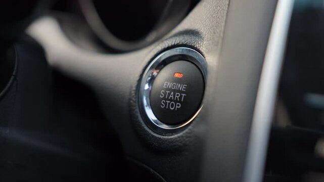 Unrecognizable male driver pushing start ignition button switch in modern luxury car. Close up of adult person pressing engine start button by finger inside car salone. Concept of new car.