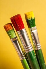 Fototapeta premium Paint brushes in green, yellow, and red for Black History Month background