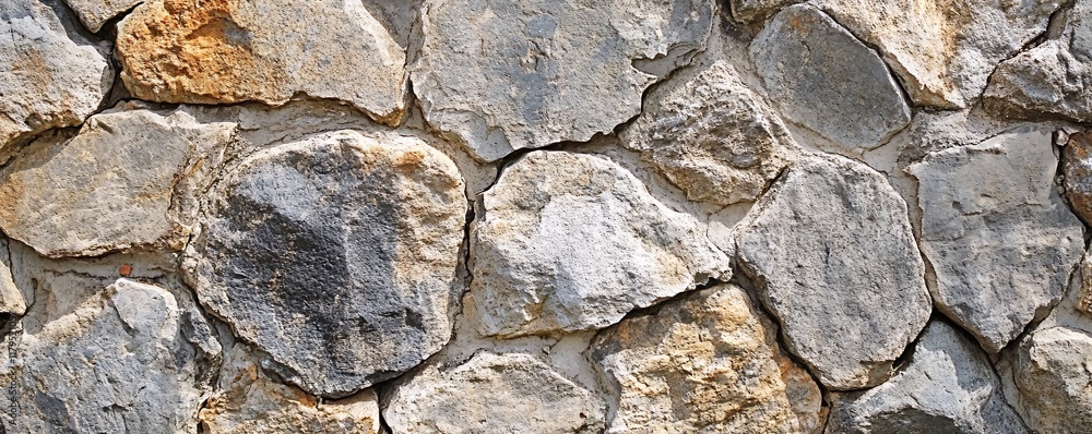 Aufkleber Stone wall showing various shapes and textures creating rustic background