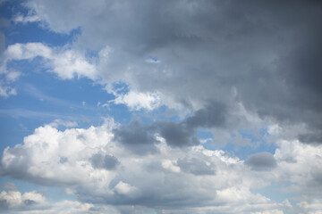 Blue sky background with rain clouds. Cumulus clouds in the blue sky.
