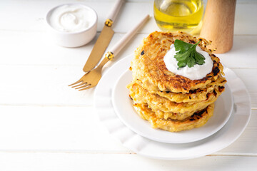 Vegetarian comfort food, potato pancakes. Traditional european vegetable dish, potato fritters, cutlets, latkes (flapjacks, hash brown or potato vada) with sour cream