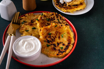 Vegetarian comfort food, potato pancakes. Traditional european vegetable dish, potato fritters, cutlets, latkes (flapjacks, hash brown or potato vada) with sour cream