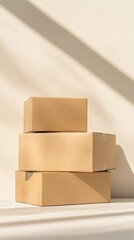 Stacking three closed cardboard boxes of varying sizes on a white surface, with natural sunlight casting strong diagonal shadows, creates a minimalist, modern aesthetic