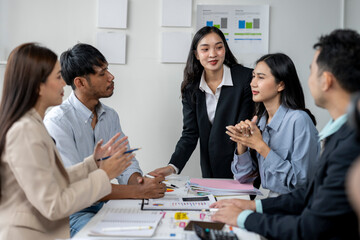 A group of people are sitting around a table, some of them are women