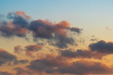 The clouds in the twilight sky, the blue sky, the setting sun, and the clouds.