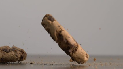 Chocolate Chip cookies falling into table surface capturing the impact in super slow-motion with crumbs flying in the air