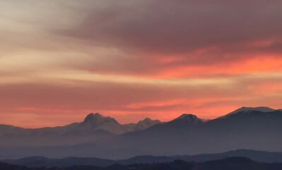 Nuvole rosse tramonto sopra le montagne 