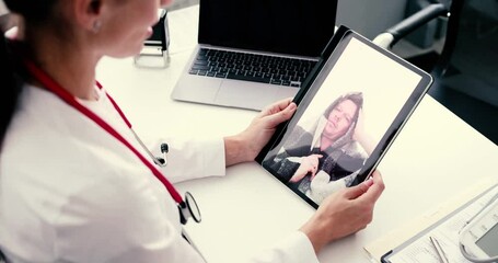 A healthcare professional conducts an online virtual consultation with a patient using a tablet device effectively