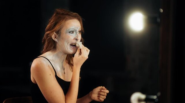 Professional actress or model wiping face by napkins, remove makeup, portrait. Skin care and beauty, woman cleaning skin from makeup and showing her true self, stay yourself or playing role in society