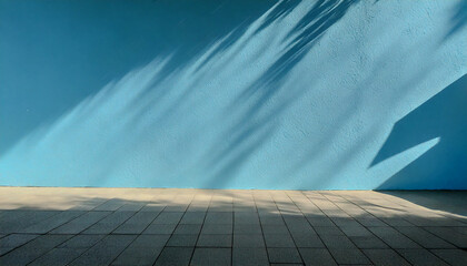 Blue Wall with Leaf Shadows,A blue wall with shadows of leaves and branches cast on it, and a textured pavement below.