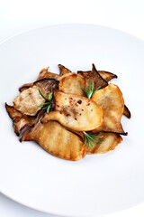 Fried Pleurotus eryngii mushrooms on a white plate.