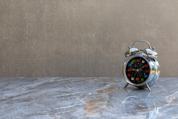 Chrome alarm clock on marble surface with space for text.