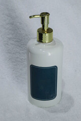 white soap body wash or shampoo dispenser on white towel background