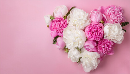 Obraz premium Heart shaped bouquet of pink and white peonies against pink backdrop. Top view.