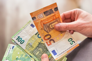 Man's hands counting euro banknotes. Close-up of man's hands counting money. Financial management, energy costs, saving money and inflation in winter season