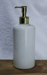 white soap body wash or shampoo dispenser on white towel background