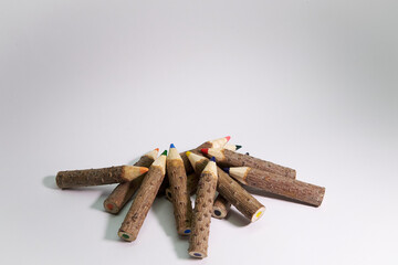 Original colored pencils, made with tree branches of the same size on a white background with space...