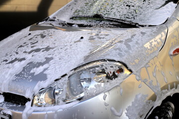 Gray car at self-service car wash. Washing car with cleaning soap