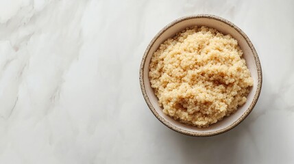 Bowl of Cooked Organic Quinoa on Marble Surface with Natural Light Background