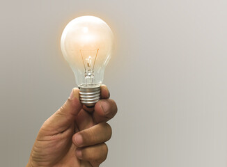 Hand hold light bulb inspired by innovative business idea, successful startup in concept