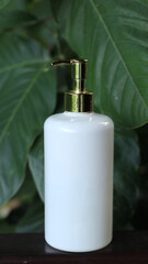 white soap body wash or shampoo dispenser on green bokeh background
