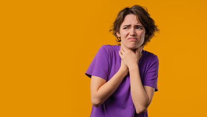 Obraz premium Pretty woman has sore. Sick lady with swollen throat on yellow studio. Angina. Young girl feels pain, ache. Seasonal flu, cold disease.