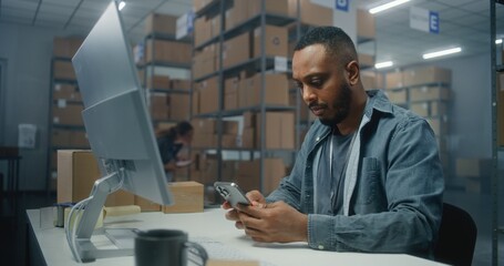 African American logistics manager scans parcel using smartphone, works in post office warehouse....