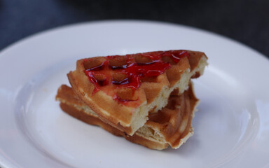 waffles with strawberry jam on white plate for brakfast