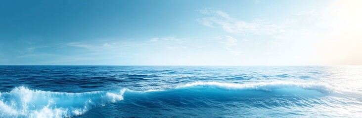 A stunning panoramic view of the ocean with gentle waves under a clear blue sky, capturing the serene beauty of nature and the vastness of the sea.