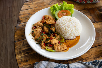 Seafood fried rice with egg, served on a white plate, on a wooden table, ready to serve. Thai food, close up food.