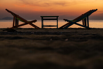 Silhouette of a chair at sunrise on a beautiful beach in Thailand.