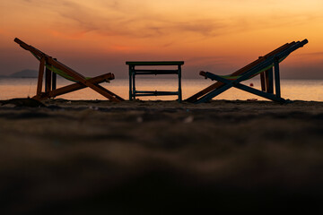 Silhouette of a chair at sunrise on a beautiful beach in Thailand.